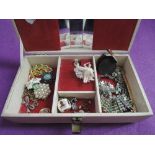 A vintage jewellery case containing a small selection of costume jewellery