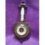 A vintage wall mounted barometer with enamel face