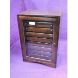 A wooden coin cabinet with nine drawers and glass door