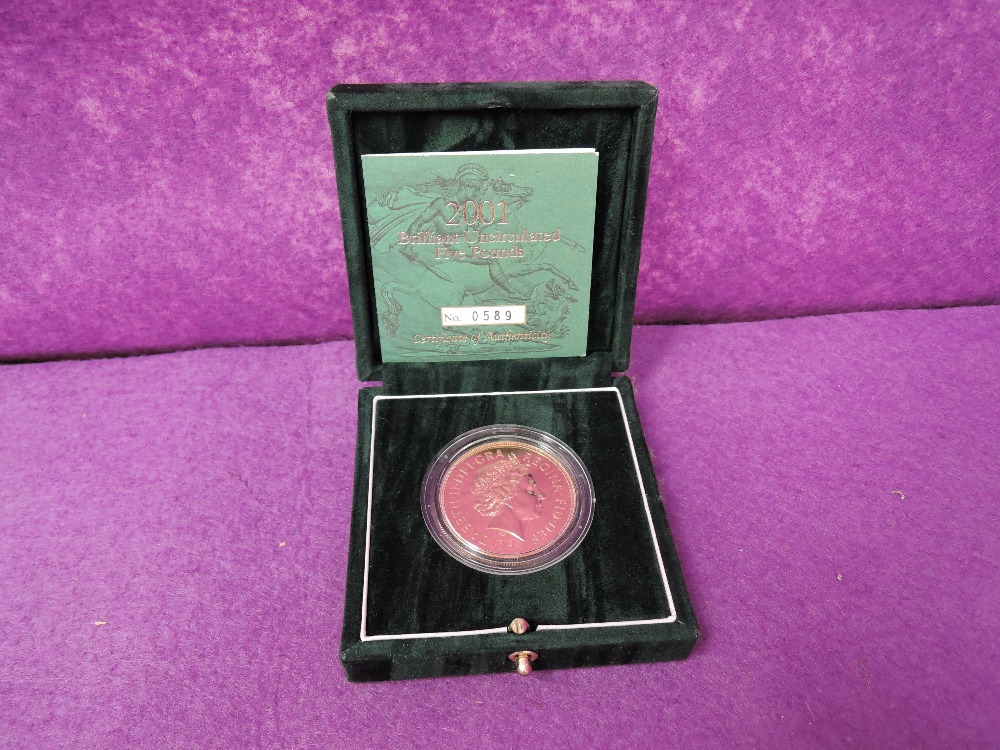 A gold 2001 United Kingdom Elizabeth II brilliant uncirculated five pound coin, in a case with