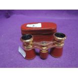 A vintage pair of opera glasses in a red leather and gilt style