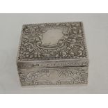 A Victorian silver cigarette box of square form having engraved and embossed scroll and shell