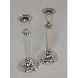 A pair of silver candle sticks having gadrooned decoration to rim and tapered stems, Birmingham