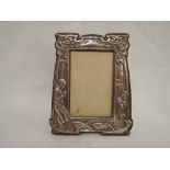 An Edwardian silver Art Nouveau design photograph frame having embossed decoration depicting a