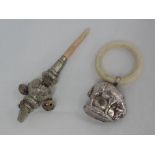 A baby's teething ring having moulded white metal sheep rattle, no marks tested as silver, and a