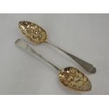 A pair of Georgian silver berry spoons having silver gilt bowls and bright cut engraving to stems,