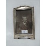 A silver photograph frame of arched rectangular form having wooden easel stand, Chester 1913, makers