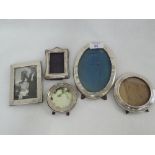 Five HM silver photograph frames of plain form having wooden and material easel backs