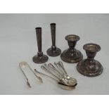 A small selection of HM silver including a pair of bud vases, pair of squat candle sticks and a