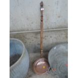 A vintage copper bed warmer