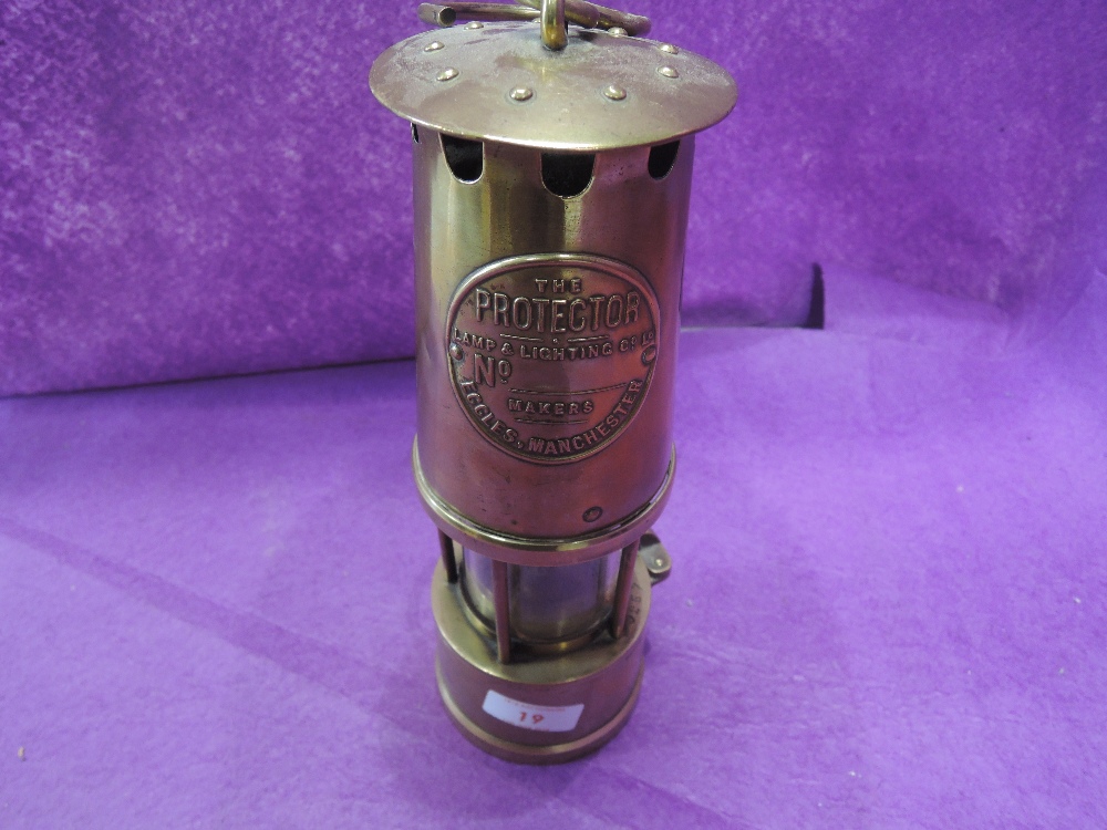 A vintage brass cast miners lamp 'The Protector' of Eccles Manchester