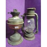 A vintage oil burning lamp and similar storm lantern