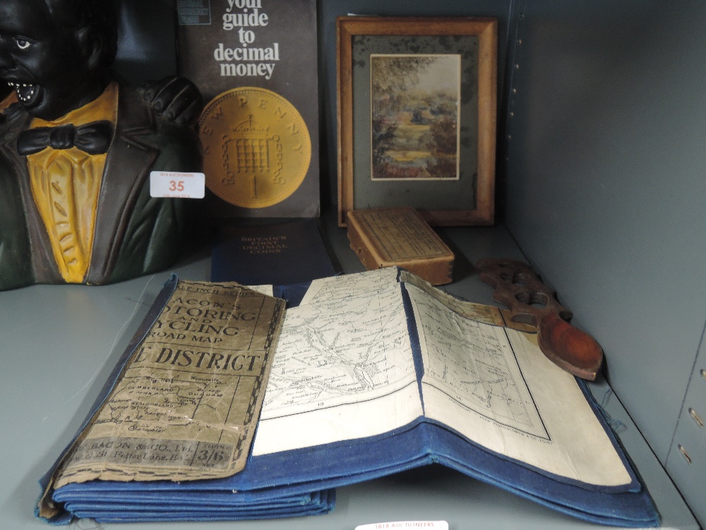 A selection of curios and trinkets including miniature water colour and Lake district map