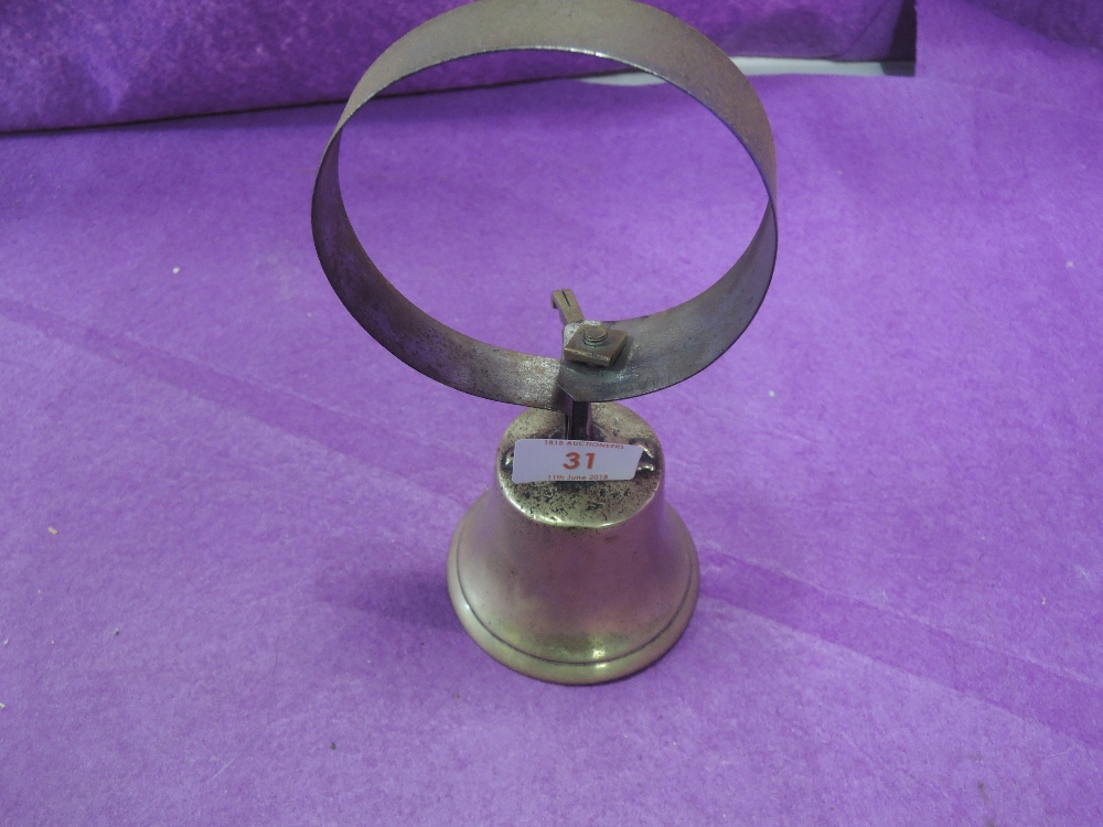 A vintage brass door bell with spring mechanism