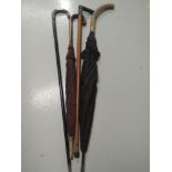 A selection of vintage walking sticks and umbrellas