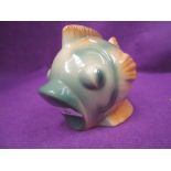 A vintage ceramic money box in the form of a stylised fish