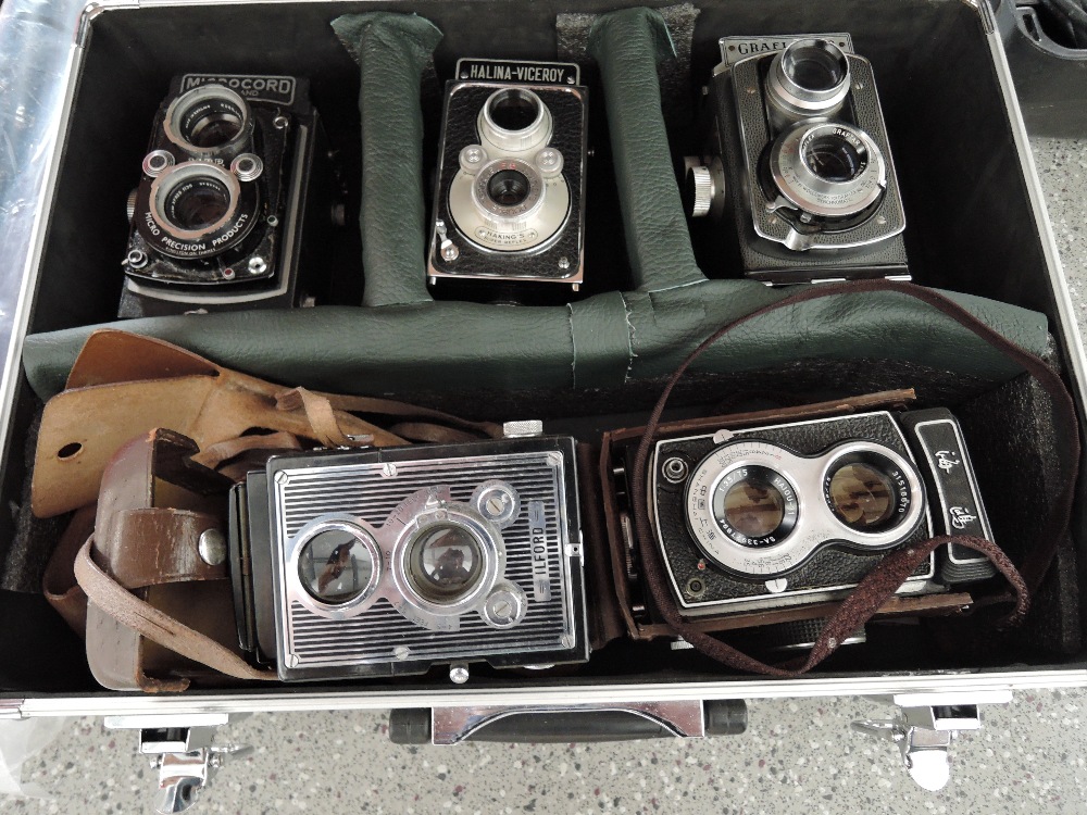 An Alloy camera case containing five reflex cameras, a Microcord, a Halina-Viceroy, a Graflex 22, an