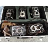 An Alloy camera case containing five reflex cameras, a Microcord, a Halina-Viceroy, a Graflex 22, an