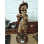 A carved treen boy playing a flute