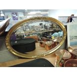 A vintage style gilt and plaster effect oval mirror