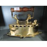 A vintage brass cast stove iron and stand