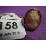 A lady's conche shell cameo ring depicting a maiden in profile in a collared mount on a 9ct gold