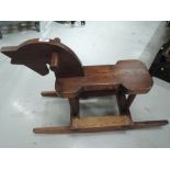 A wooden hand made rocking horse having rocking base