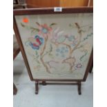 A folding fire screen/ table with embroidered decor