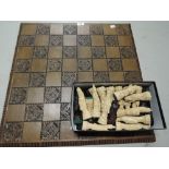 A vintage chess set and board with Chinese style figures