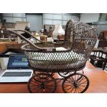 A vintage wicker style childs or dolls pram