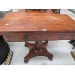 An antique mahogany swivel top tea table