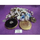 A small selection of costume jewellery including strings of beads, earrings, compacts etc