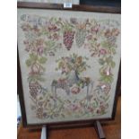 A vintage fire screen with embroidery panel
