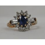 A lady's dress ring having a sapphire and diamond cluster with two princess cut diamonds to