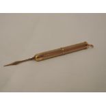 A 9ct gold retractable tooth pick having engine turned decoration