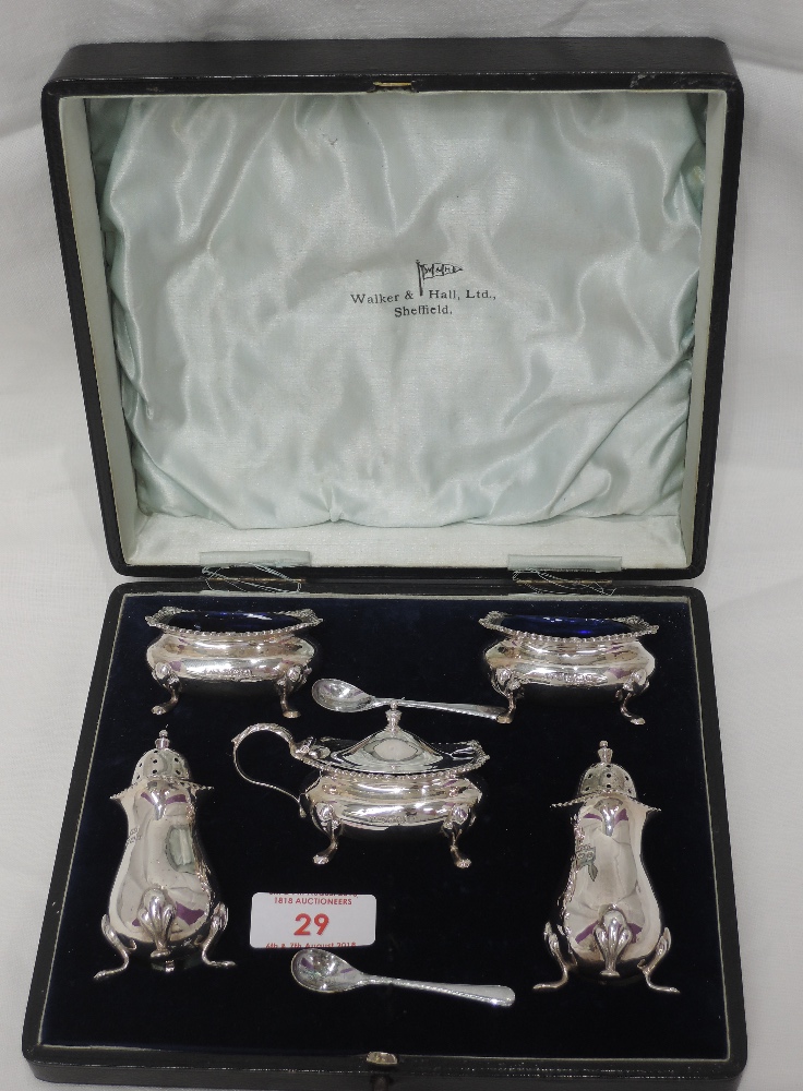 A cased 5 piece silver condiment set of plain baluster form having gadrooned rims and paw feet,