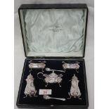 A cased 5 piece silver condiment set of plain baluster form having gadrooned rims and paw feet,