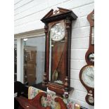 An early 20th century stained frame Vienna wall clock of traditional style with half pillars and