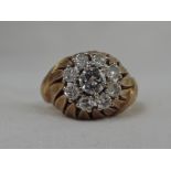 A lady's 1960's style dress ring having a diamond daisy cluster in a raised moulded stylised leaf