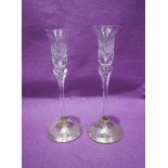 A pair of cut glass candle sticks having circular silver stepped bases, Birmingham 1988, W I