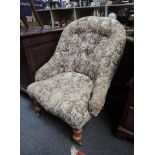 A Victorian tub armchair having late 20th century tapestry upholstery on turned front legs