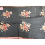 A piece of black woven upholstery material having woven floral clusters