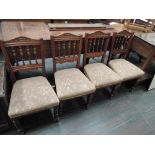 A set of four late Victorian mahogany dining chairs having spindle backs and later moquette