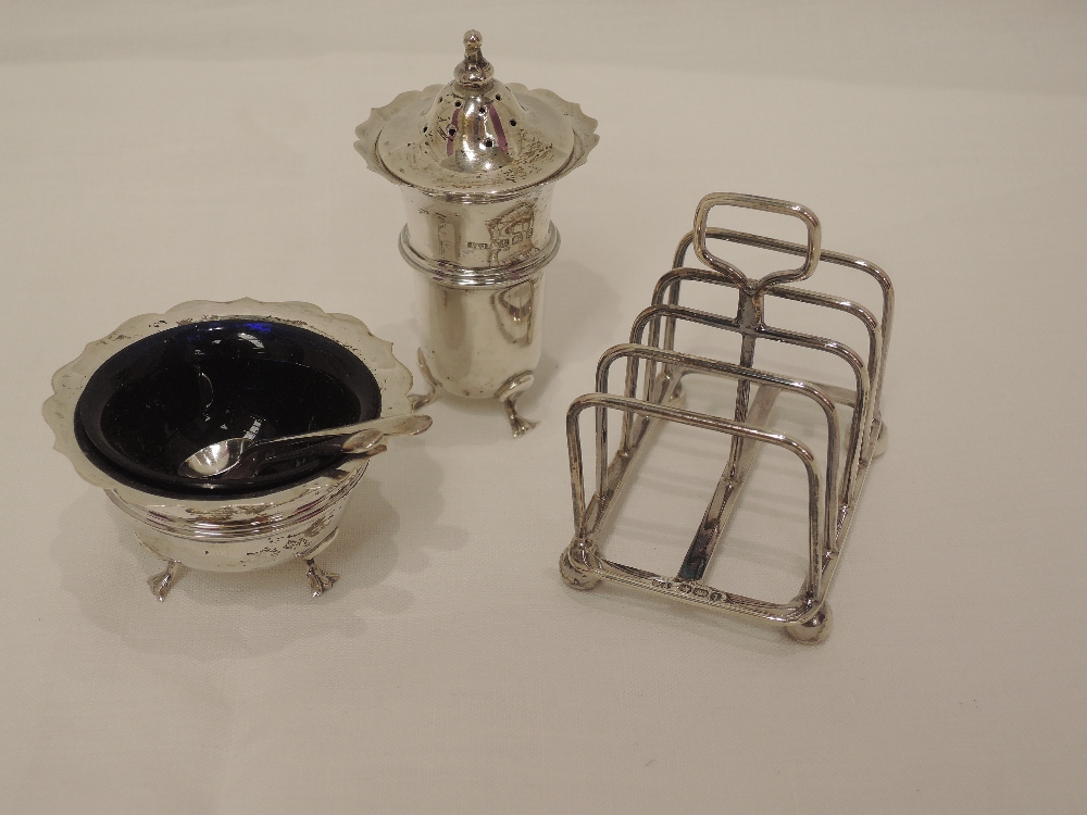 An Edwardian silver pepperette and salt of plain form having shaped rims and trefoil paw feet,