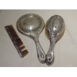 A three piece silver dressing table set having moulded scroll decoration, Birmingham 1912, Henry