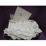 A box of vintage linen including cotton bonnet, lace edged pillow cases, table linen etc