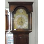 A late 18th century dark oak longcase clock having square and reeded pillar hood containing arch,