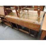 An early 19th century elm vernacular table having drop flaps to rectangular top on square