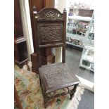 A 19th century oak hall chair in the 17th century style, having carved arch and panel back with