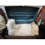 A vintage tin trunk containing a large quantity of vintage net and lace pieces